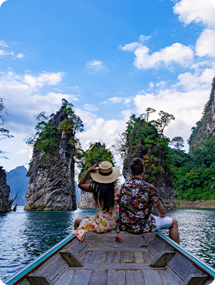 people-sitting-rock-by-water-against-sky